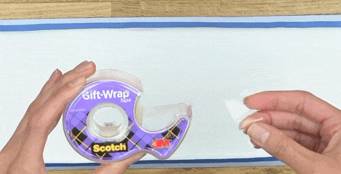 Manos de mujer envolviendo una caja con papel de otro color y pegando todo con Cinta de Regalo Scotch®.

