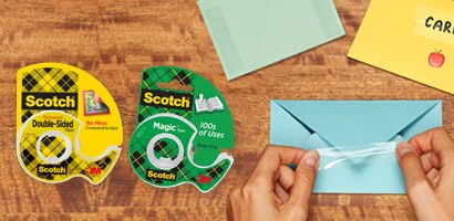 Uso de producto Cintas Adhesivas Scotch® en sobre color azul, packshot Cinta Doble Cara Scotch® y packshot Cinta Mágica Scotch®.
