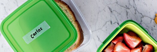 Recipientes de alimentos con Cinta Mágica Scotch® pegada donde se escribió un nombre.